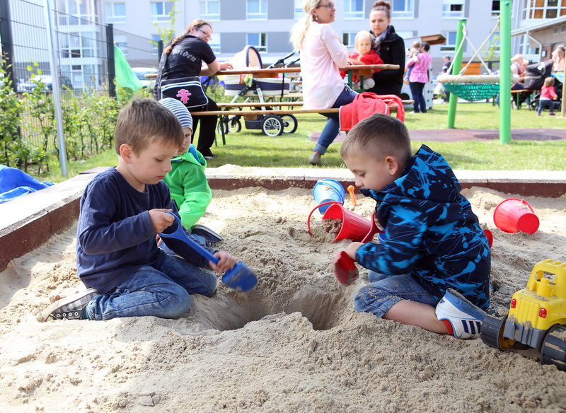 ASB-Seelzelino Drei Kleinkinder sitzen in einer Sandkiste und buddeln ein tiefes Loch