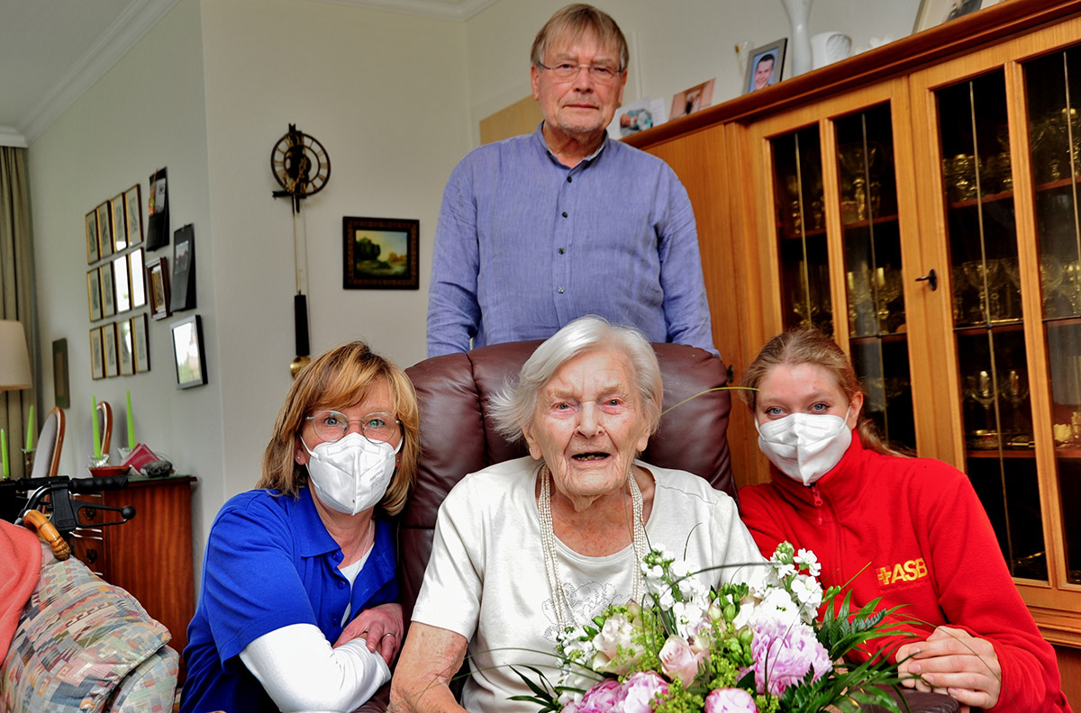 Aelteste-Kundin-Hauswirtschaft.jpg Tina Marks (li.) und Dominique Kolla-Werger (re.) vom ASB überraschen Anneliese Grund und ihren Sohn Uwe Grund mit einem Blumenstrauß